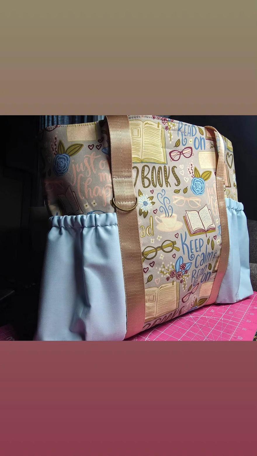 Medium (9 1/2" x 12" x 2 1/2") Reading Themed Carryall with 4 outside pockets, 2 inside pockets and a D ring to clip keys, coin pouch or badge.